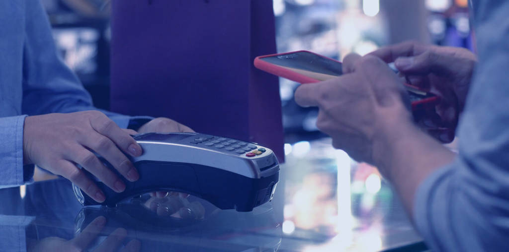 A person finishes a transaction at a tap to pay card reader