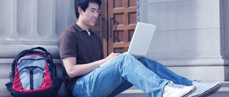 student sitting on steps with laptop